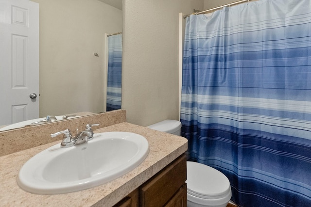 bathroom with walk in shower, vanity, and toilet