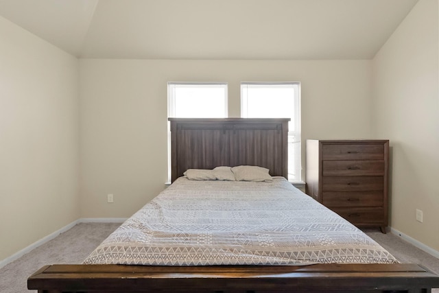 carpeted bedroom with lofted ceiling