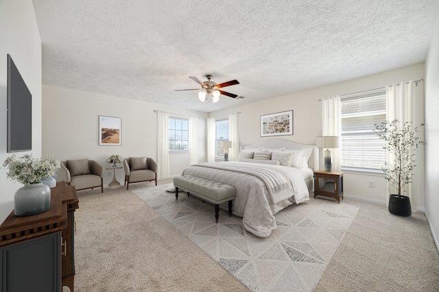 carpeted bedroom with ceiling fan and a textured ceiling