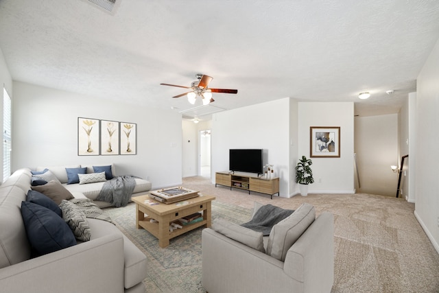 carpeted living room with ceiling fan and a textured ceiling