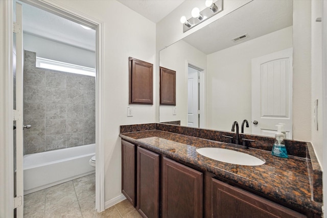 full bathroom featuring tile patterned floors, vanity, toilet, and tiled shower / bath combo