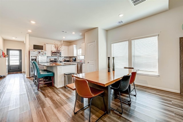 dining area featuring light wood finished floors, visible vents, and recessed lighting