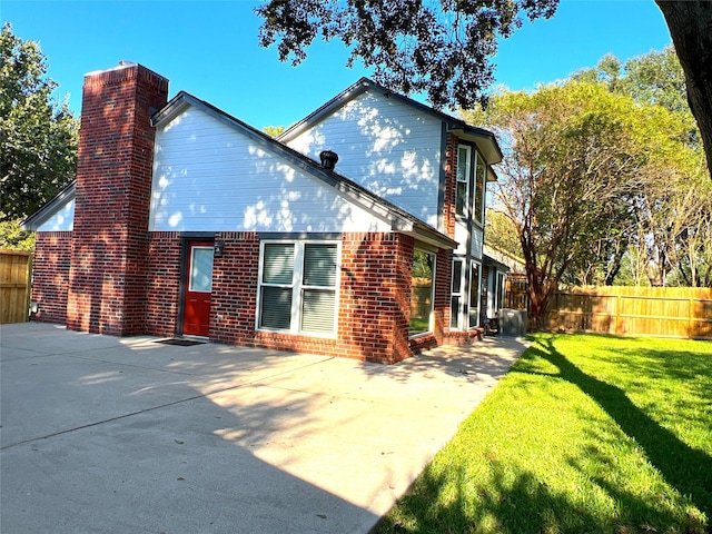 back of property featuring a patio area and a yard