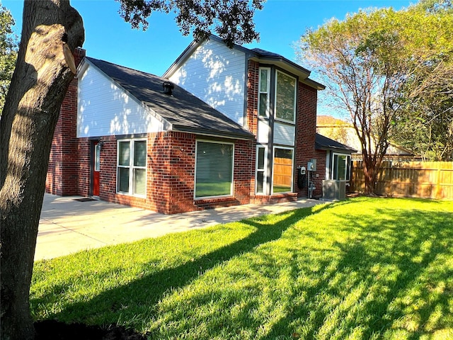 back of house with a lawn and a patio