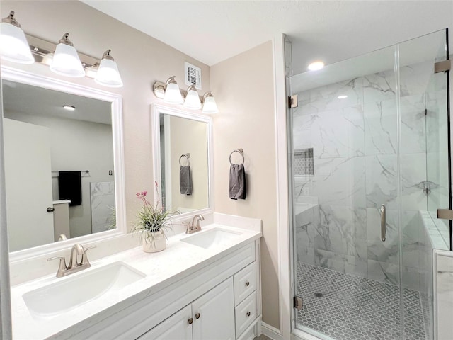 bathroom with vanity and a shower with door