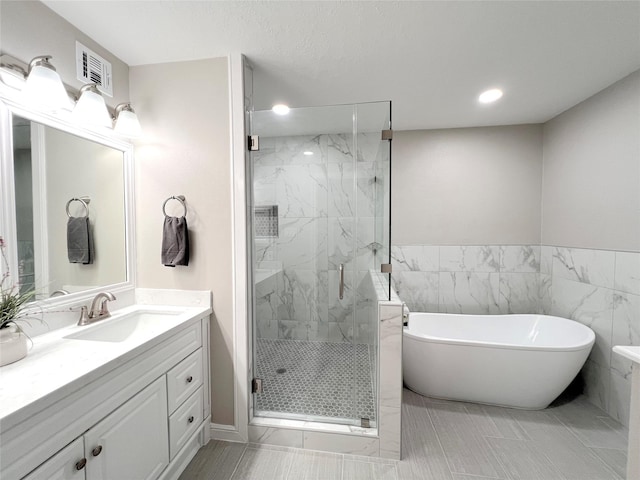 bathroom with tile patterned flooring, shower with separate bathtub, and vanity