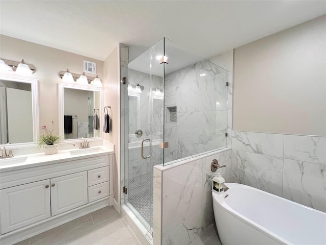 bathroom with tile patterned flooring, vanity, tile walls, and independent shower and bath