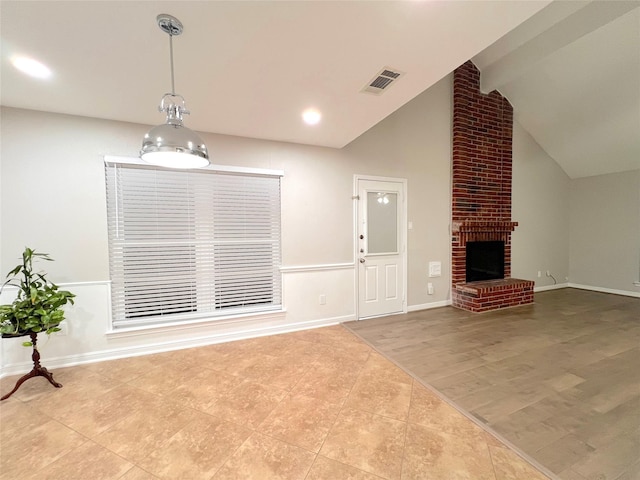 unfurnished living room with a fireplace, vaulted ceiling with beams, and light tile patterned flooring