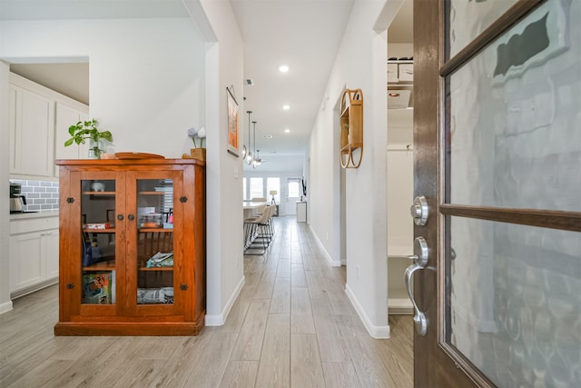 corridor with light hardwood / wood-style floors