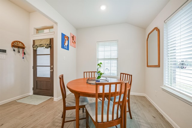 dining room with light hardwood / wood-style floors and lofted ceiling