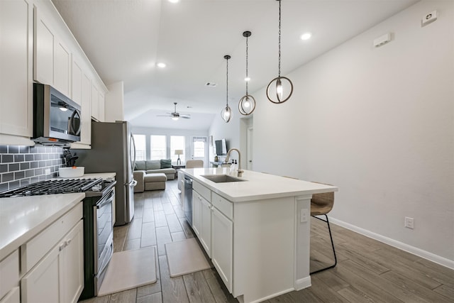 kitchen with a kitchen island with sink, sink, white cabinets, and stainless steel appliances