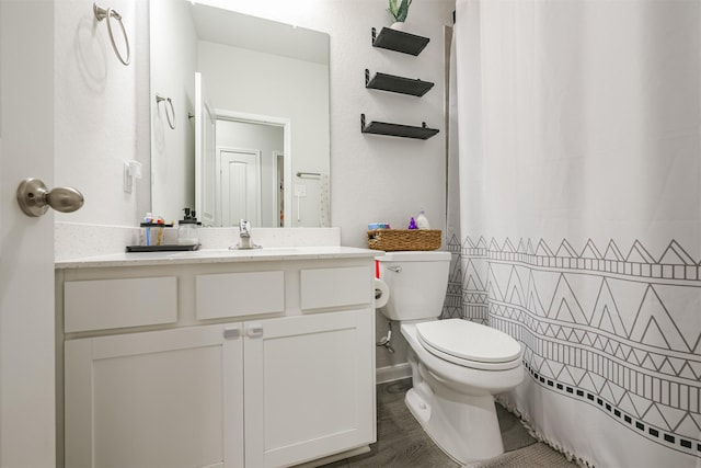 bathroom featuring curtained shower, hardwood / wood-style floors, vanity, and toilet