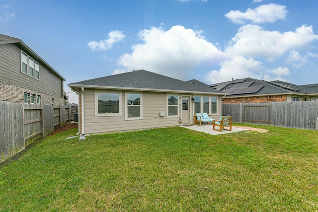 back of house with a patio and a lawn