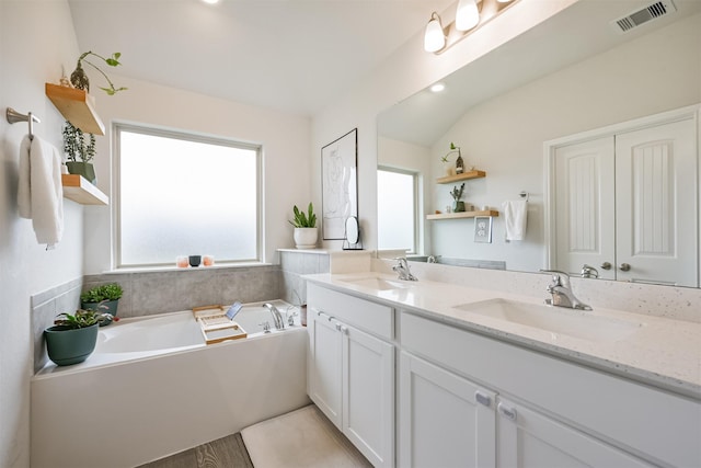 bathroom with a tub, vanity, and wood-type flooring