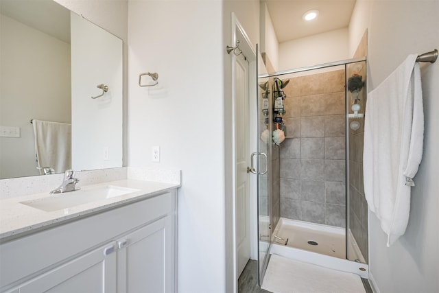 bathroom with hardwood / wood-style floors, vanity, and a shower with shower door