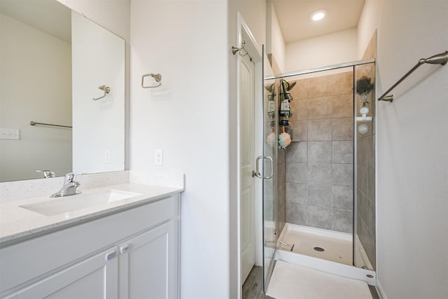 bathroom featuring hardwood / wood-style flooring, vanity, and a shower with shower door