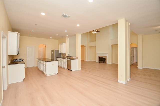 kitchen with ceiling fan, white cabinetry, appliances with stainless steel finishes, and light hardwood / wood-style flooring