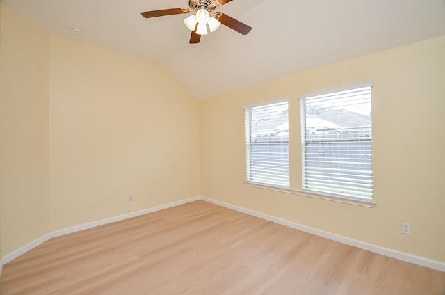 spare room with light hardwood / wood-style flooring, vaulted ceiling, and ceiling fan