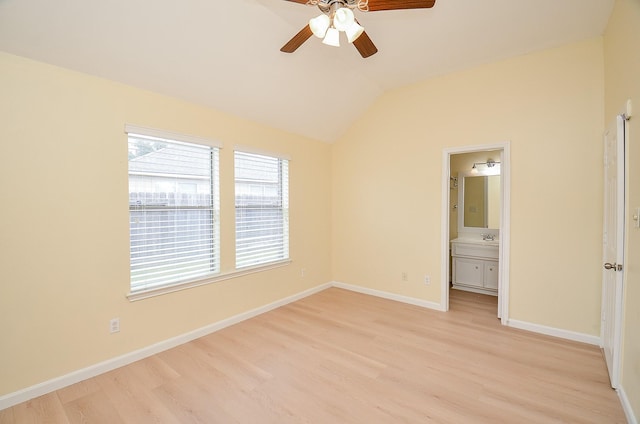 unfurnished bedroom with lofted ceiling, ensuite bathroom, sink, ceiling fan, and light wood-type flooring