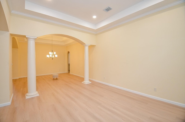 interior space featuring hardwood / wood-style flooring, a raised ceiling, ornamental molding, and a chandelier