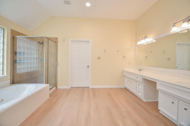 bathroom with vanity, hardwood / wood-style flooring, independent shower and bath, and lofted ceiling