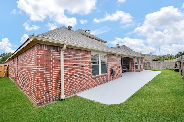 back of house with a patio area and a lawn