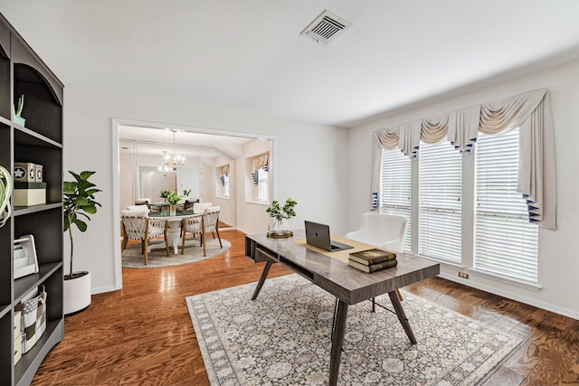 home office with dark hardwood / wood-style flooring and a chandelier