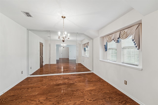 interior space featuring dark hardwood / wood-style flooring and a chandelier