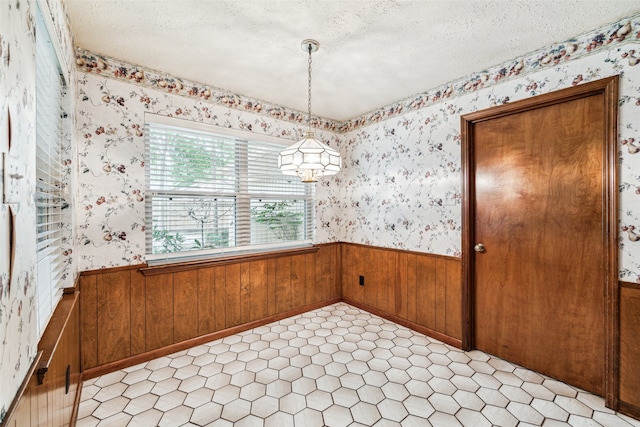 empty room featuring a notable chandelier and a textured ceiling