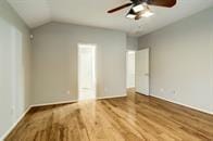 empty room with wood-type flooring and lofted ceiling