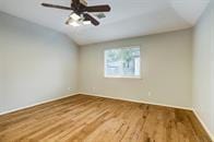 empty room featuring hardwood / wood-style floors and lofted ceiling