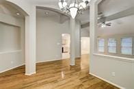 interior space with hardwood / wood-style floors and ceiling fan with notable chandelier