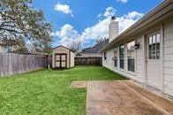 view of yard featuring a patio and a storage shed