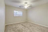 carpeted spare room featuring ceiling fan