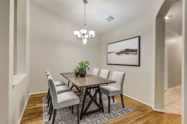 dining area with hardwood / wood-style flooring and a chandelier