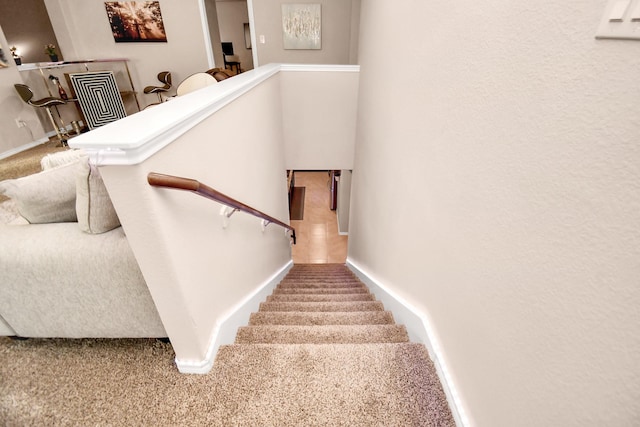 staircase featuring carpet flooring