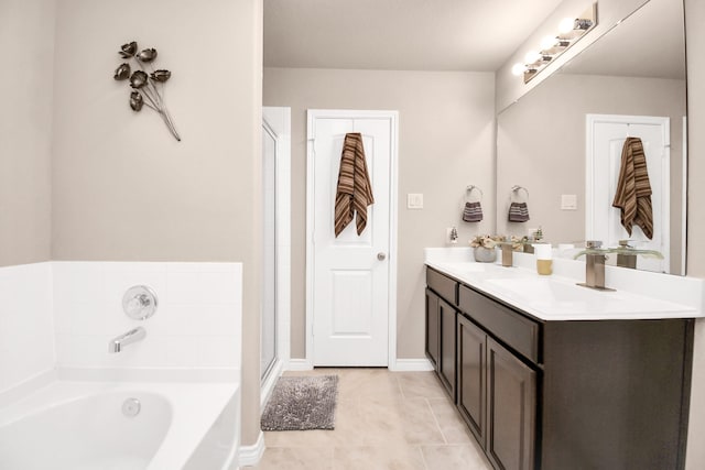 bathroom with tile patterned flooring, vanity, and a bath