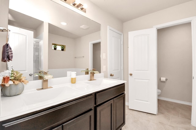 bathroom featuring tile patterned floors, vanity, toilet, and a shower with door