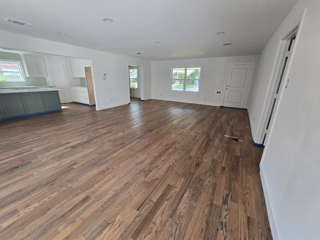 unfurnished living room with dark wood-type flooring