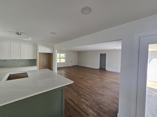 kitchen featuring dark wood-type flooring, white cabinets, light stone counters, tasteful backsplash, and cooktop