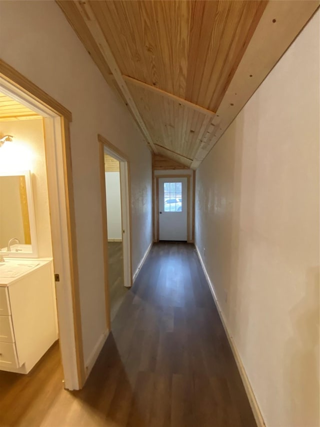 hall with hardwood / wood-style flooring, lofted ceiling, and wood ceiling