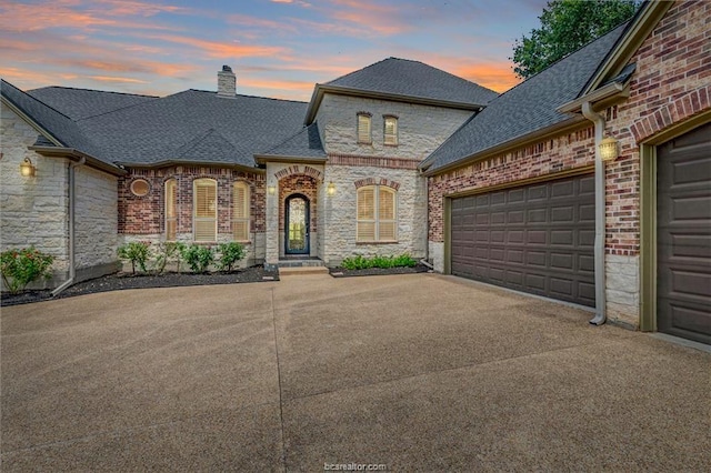 french provincial home featuring a garage