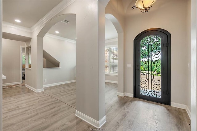 foyer featuring light hardwood / wood-style floors and crown molding