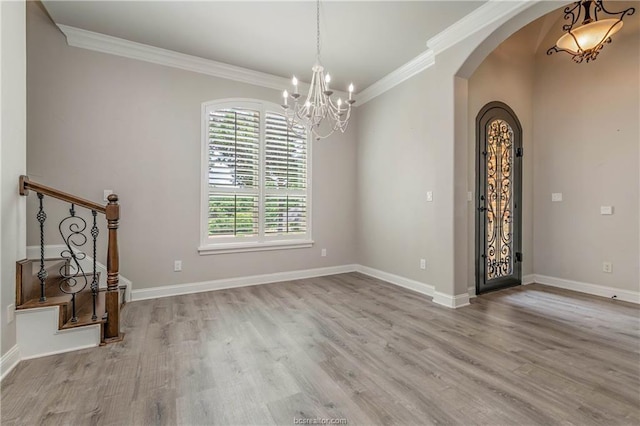 interior space featuring crown molding, an inviting chandelier, and light wood-type flooring