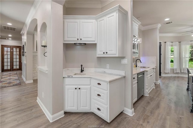 kitchen featuring white cabinets, dishwasher, sink, and light hardwood / wood-style flooring