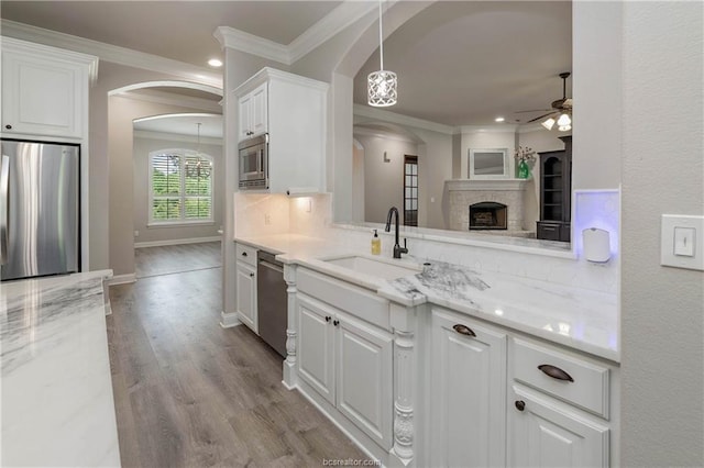 kitchen featuring ceiling fan, white cabinets, stainless steel appliances, and light stone counters