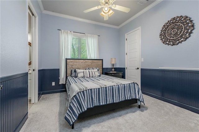 carpeted bedroom with ceiling fan and ornamental molding