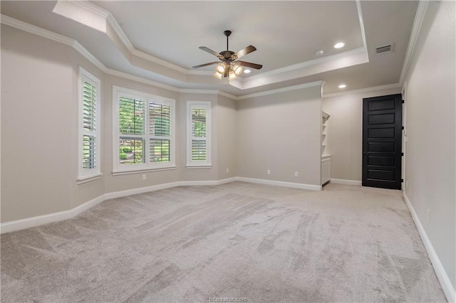 carpeted spare room featuring ceiling fan, a raised ceiling, and ornamental molding