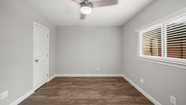 empty room with ceiling fan and dark hardwood / wood-style flooring