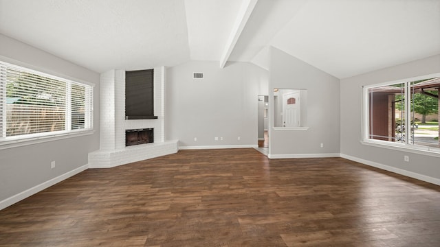 unfurnished living room with vaulted ceiling with beams, dark wood-type flooring, and a brick fireplace